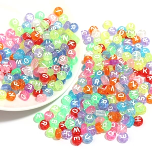 Détail macro de perles de lettres rondes en acrylique avec lettres blanches et couleurs vives