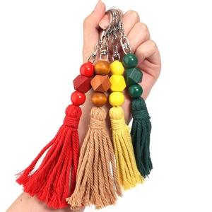 Llaveros de cuentas de madera de colores macarrón con borlas de algodón en la mano