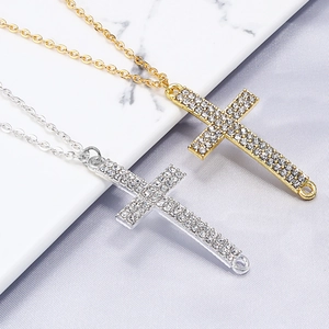 Gold- und Silber-Kreuzanhänger-Halsketten mit Strass-Pavé auf Marmorhintergrund