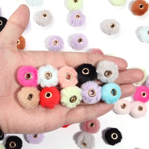 Macro shot of colorful faux rabbit fur pom poms with metal eyelets for DIY jewelry making