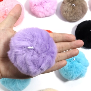 Close-up of fluffy colorful mink fur balls with elastic loops for DIY crafts and decor