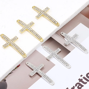 Makro-Detail von diamantbesetzten Kreuzanhängern mit doppelten Ösen für DIY-Schmuck