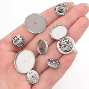 Macro view of stainless steel lapel pin bases and butterfly clutch backs on a hand