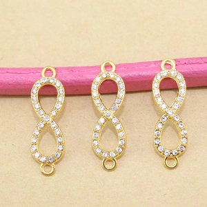Nahaufnahme von vergoldeten Unendlichkeits-Anhängern mit Zirkonia-Mikropavé für DIY-Schmuck