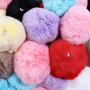 Macro shot of colorful mink fur pom poms with elastic loops for DIY crafts and decor