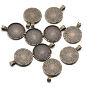 Detailed macro view of bronze alloy round pendant tray bases for DIY jewelry making