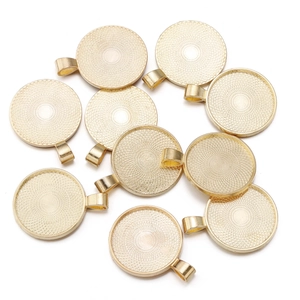 Macro detail of round golden alloy pendant bezel trays with vintage grid patterns for DIY