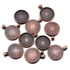 Detailed macro view of vintage bronze alloy round pendant trays with radial textures