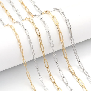 Detailed close-up of gold and silver paperclip chains on a curved jewelry display stand