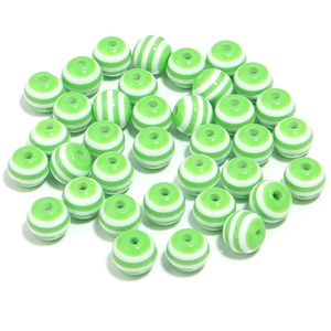 Macro detail of 20mm green and white striped resin beads for DIY jewelry making
