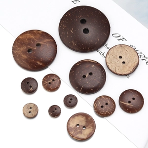Macro detail of various sizes of round natural coconut shell buttons with two holes