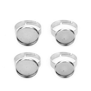 Close-up of four silver stainless steel adjustable ring bases with round flat trays