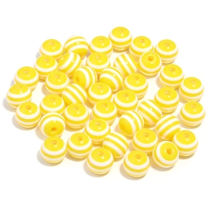 Macro detail of 20mm yellow and white striped resin beads for DIY jewelry making