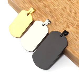 Polished stainless steel dog tag pendants in gold, silver, and black on a wood base
