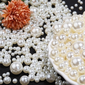 Close-up of assorted high-gloss white ABS faux pearls in various sizes for DIY crafts