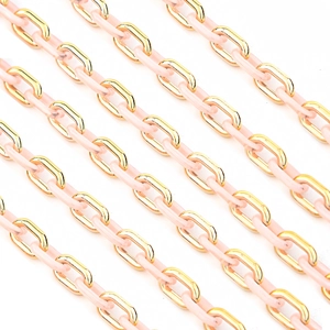 Detailed macro view of pink enamel and gold metal interlocking chain links for DIY jewelry