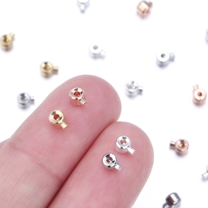 Makroansicht kleiner Quetschperlen-Verschlüsse in Gold, Silber und Roségold-Finish