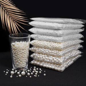 Polished white ABS imitation pearls in various sizes displayed on black background