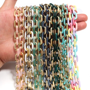 Macro detail of multi-colored acrylic and gold metal chain links for jewelry making