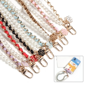 Detail of pearl phone straps with leather chain and camellia flower enamel pendants