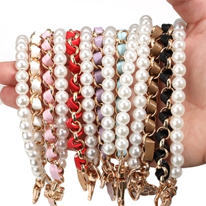 Close-up of pearl bead and leather woven straps with gold clasps in multiple colors