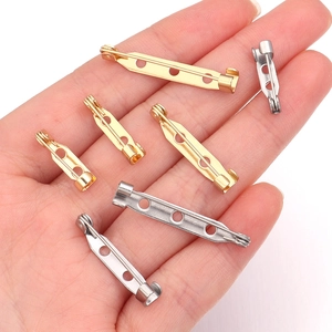 DIY 316 stainless steel brooch pin backs in gold and silver held in palm for scale