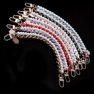 Detail of woven pearl chain straps with camellia charms and gold-tone hardware