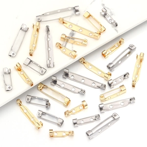 DIY jewelry brooch back pins in gold and silver finish on marble surface texture