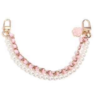 Detail of pink camellia charm with white pearls and leather woven golden chain