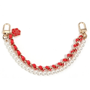 Detail of red leather chain with white pearls and red camellia flower charm on white background