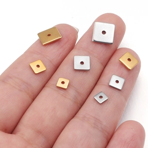 Macro shot of square stainless steel spacer beads in gold and silver for DIY jewelry
