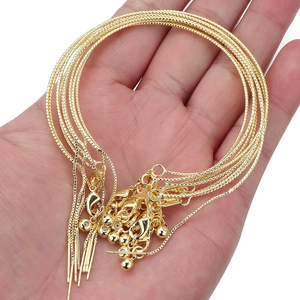 Close-up of golden copper box chains for DIY jewelry making with lobster clasp and beads