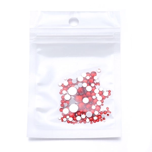 Macro shot of red and silver round flatback rhinestones for nail art in a clear PE bag