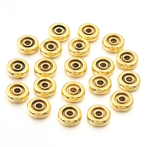 Macro-opname van twintig gouden legering tussenkralen voor DIY sieraden op witte achtergrond
