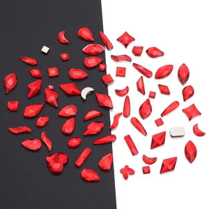 Close-up of assorted red glass rhinestones in heart, teardrop, and moon shapes