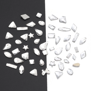 Macro view of assorted clear crystal rhinestones in various geometric shapes for nail art