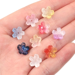 Mini gradient cherry blossom glass beads for DIY jewelry making held in a palm