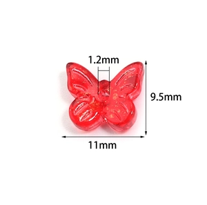 Detail of red butterfly bead with gold glitter showing 11mm width and 1.2mm hole size