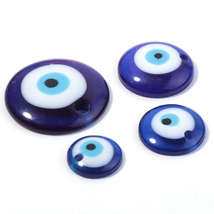 Detailed view of four sizes of flat round blue glass evil eye charms with pre-drilled holes