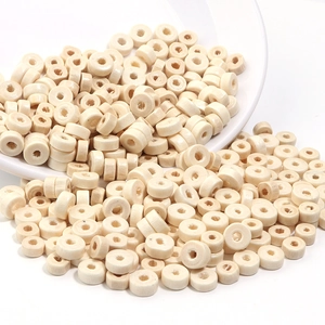 Gros plan de perles plates en bois naturel pour la création de bijoux artisanaux
