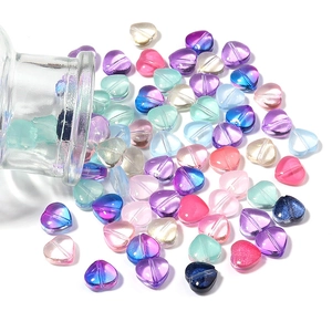 Close-up of colorful heart-shaped gradient glass beads with holes for DIY jewelry making