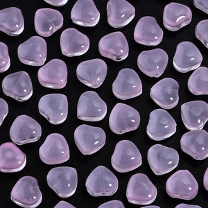 Detailed view of pink heart-shaped gradient glass beads for DIY jewelry making