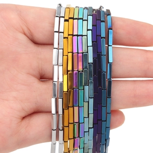 Golden and multicolored rectangular hematite beads for DIY jewelry making on palm