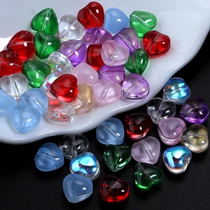 Close-up of heart-shaped colored glass beads with vertical holes for DIY jewelry