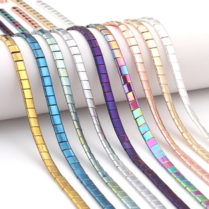 Vue macro des perles carrées en hématite colorée avec une finition métallique brillante