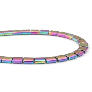 Vue macro de perles d'hématite carrées irisées à deux trous pour bijoux DIY