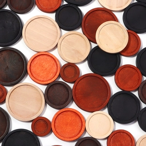 Detailed overhead view of round wooden gemstone trays in various wood tones and sizes