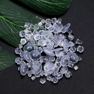 Clear silicone earring backs assortment with flower and bullet shapes on black background