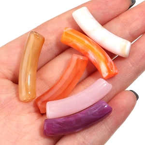 Nahaufnahme von fünf bunten Acryl-Bogenperlen für DIY-Schmuck und Armbänder