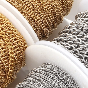 Macro shot of gold and silver plated stainless steel curb chains wound on plastic spools